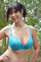 Жена в кружевном белье позирует на природе